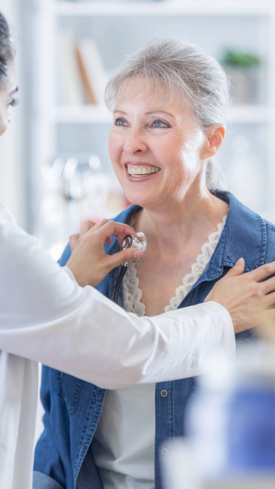 Paciente sorrindo durante a ausculta com a médica