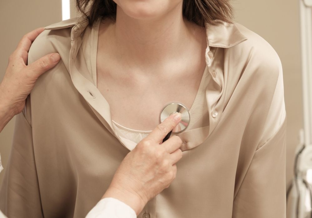 Médica auscultando o coração de uma paciente